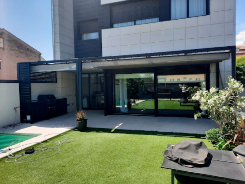 Exterior d'habitatge unifamiliar amb estructura per a tendal a terrassa