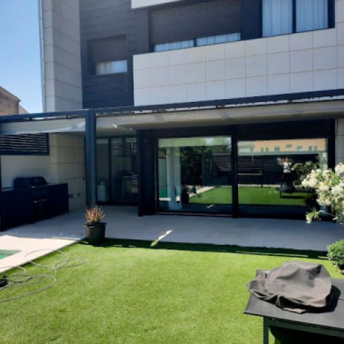 Exterior d'habitatge unifamiliar amb estructura per a tendal a terrassa